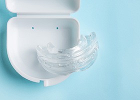 Clear nightguard in its white case with light blue background