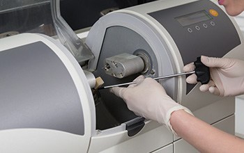 Woman working with CEREC milling unit