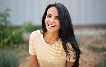 Woman in yellow shirt outside and smiling