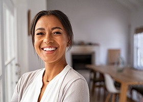 Woman in white shirt smiling in her kitchen