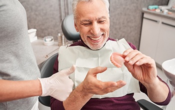A dental patient taking a closer look at dentures