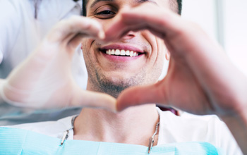 A man making a heart shape with his hands.