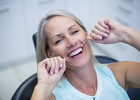 Woman flossing in Rochester