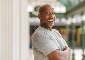 Confident man smiles with dental implants in Rochester