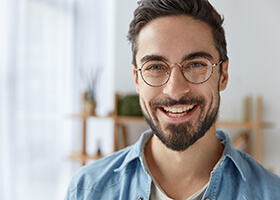 Young man with dental implants in Rochester smiling