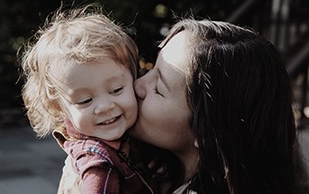 Mother giving daughter kiss on cheek
