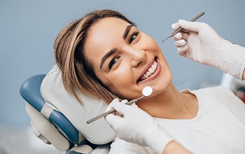 Woman in white shirt smiling during dental checkup