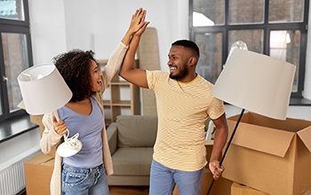 roommates unpacking their apartment and giving each other high-fives