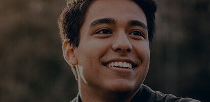 Young man grinning outdoors