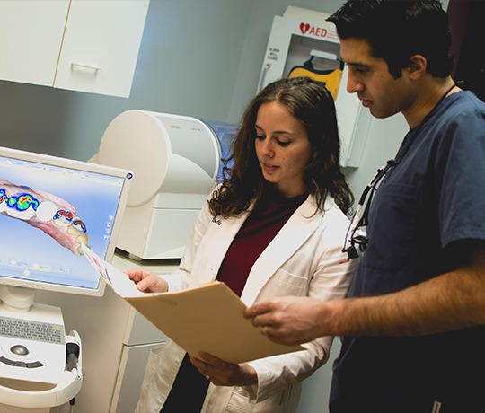 Two Rochester dentists looking at a file