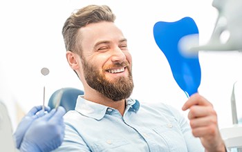 man smiling after getting veneers in Rochester