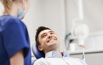 Dental assistant and patient smiling at each other during consultation