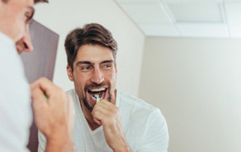 Woman smiling while holding teeth whitening tray