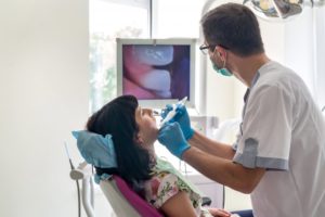 dentist examining patient's mouth with intraoral camera