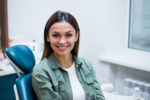 a woman sitting in the dentist chair smiling