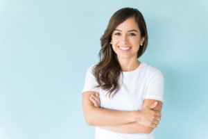 a young woman smiling with her arms folded