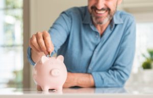 man putting chance in piggy bank