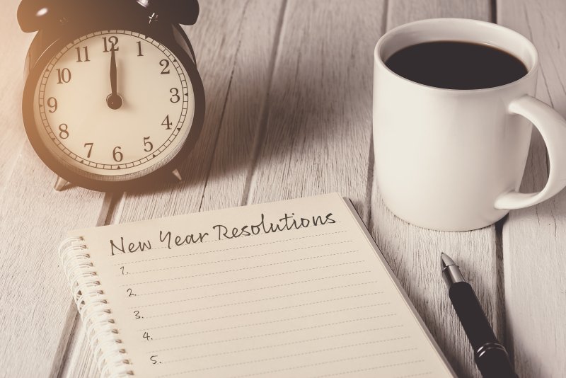 writing 2022 new year’s resolutions in journal 