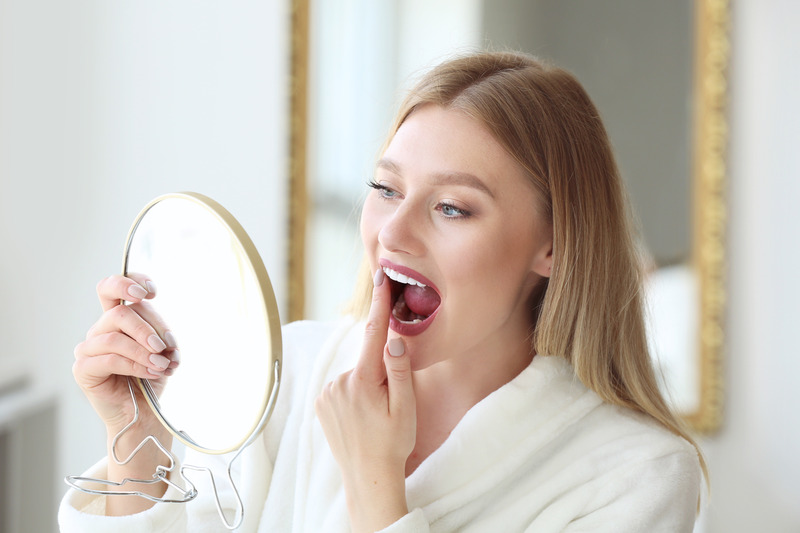 Patient smiling in mirror with dental crown