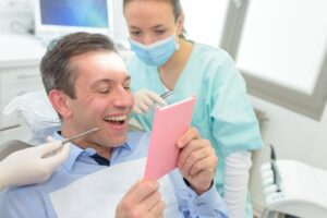 Man smiling while looking at his dental crown