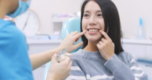 Woman talking to her dentist about bone grafts