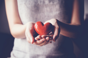 a person holding a red heart